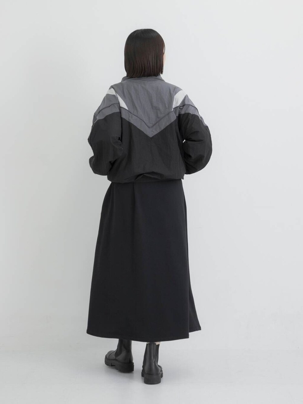 ブラック系のナイロンジャケット、ブラック系のワンピースを着用したレディースの秋コーディネートの4枚目の写真