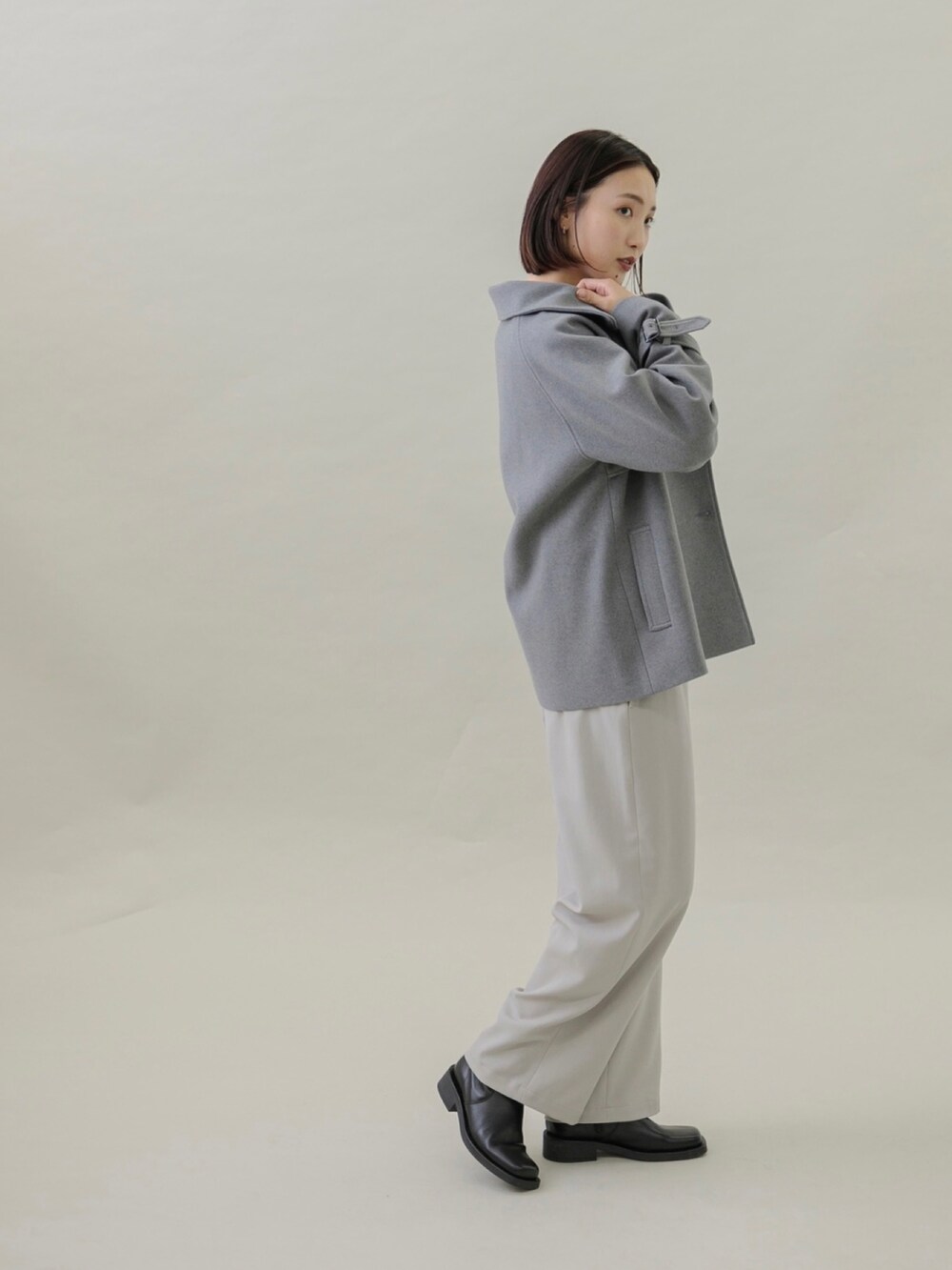 ブラック系のブーツ、グレー系のその他パンツ、ブルー系のニット/セーターを着用したレディースの秋コーディネートの2枚目の写真