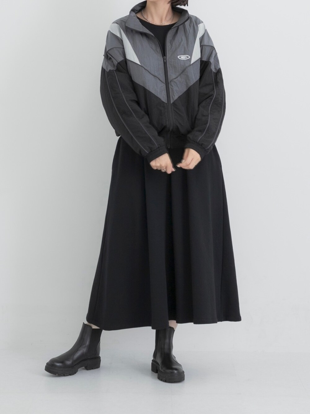 ブラック系のナイロンジャケット、ブラック系のワンピースを着用したレディースの秋コーディネートの2枚目の写真