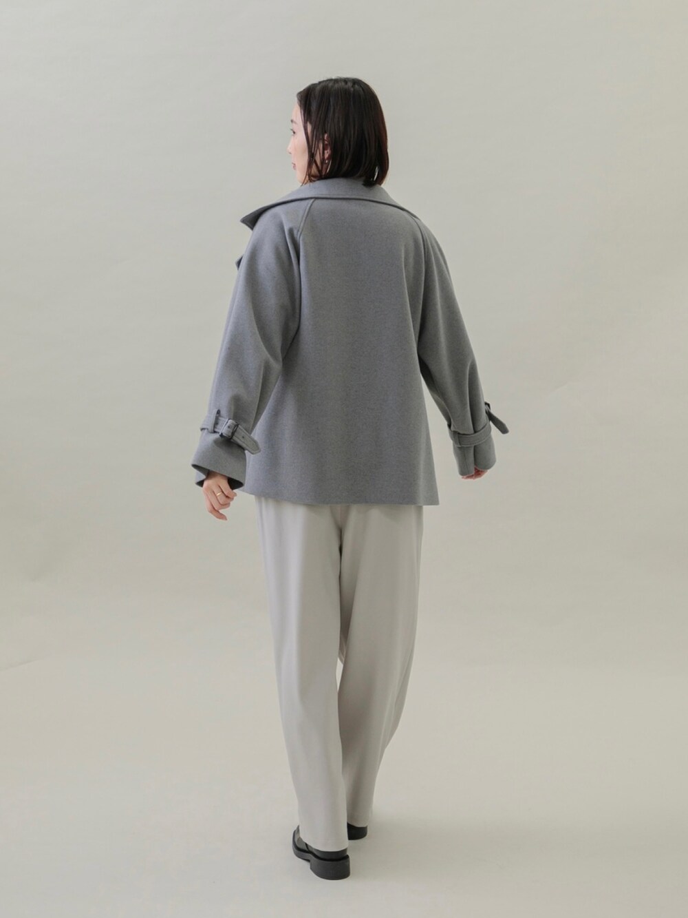 ブラック系のブーツ、グレー系のその他パンツ、ブルー系のニット/セーターを着用したレディースの秋コーディネートの3枚目の写真