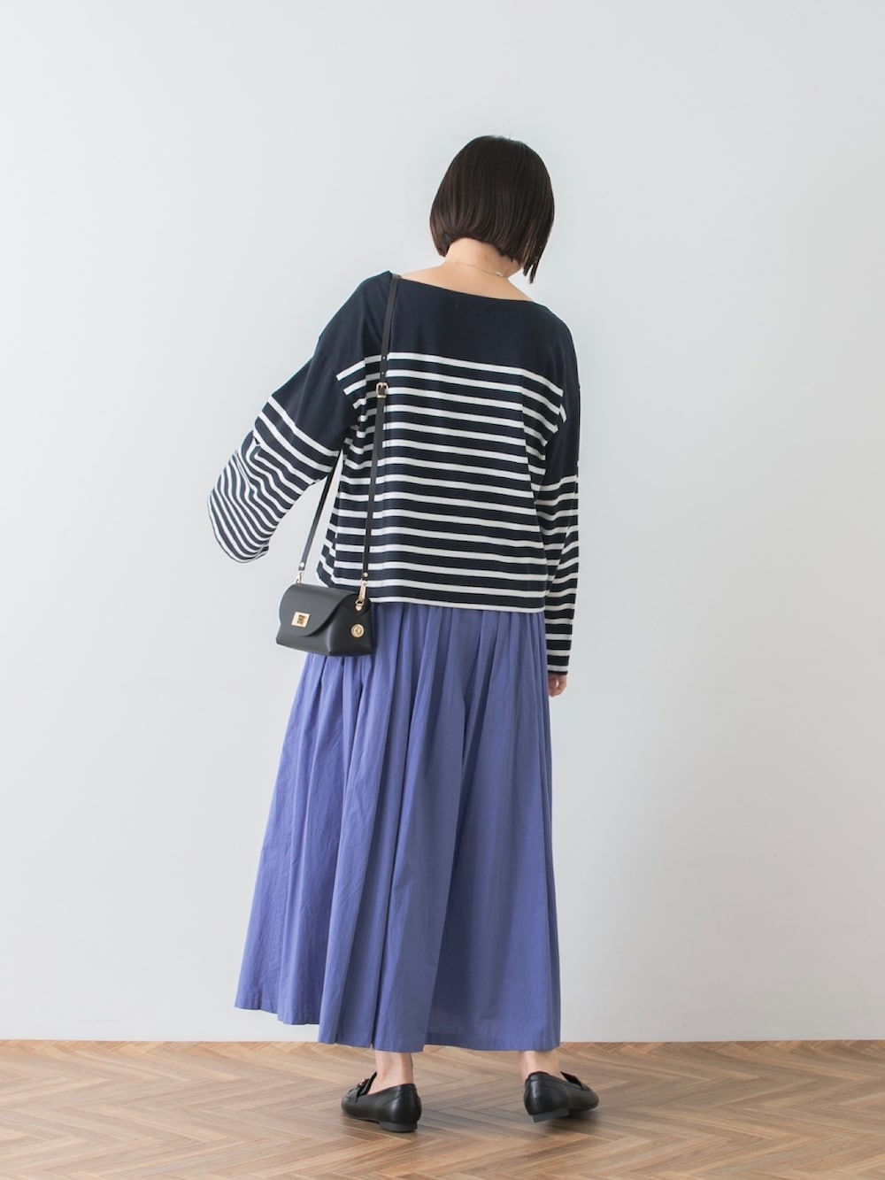 ブルー系のTシャツ/カットソー、ブルー系のスカート、ブラック系のショルダーバッグを着用したレディースの夏コーディネートの3枚目の写真