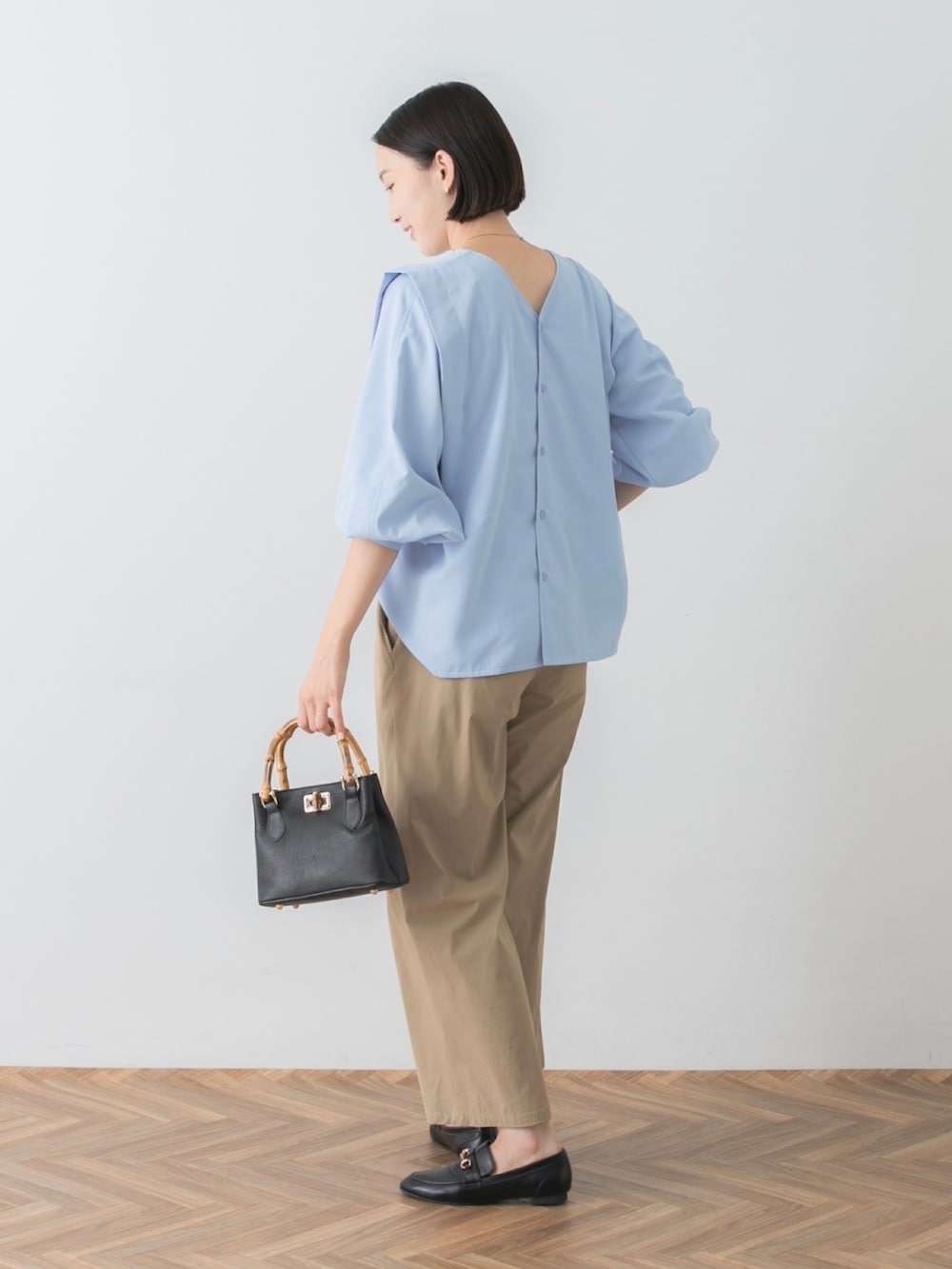 ブルー系のシャツ/ブラウス、ベージュ系のその他パンツ、ブラック系のトートバッグを着用したレディースの秋コーディネートの4枚目の写真