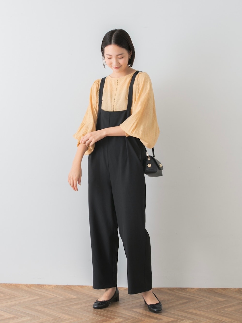 イエロー系のシャツ/ブラウス、ブラック系のサロペット/オーバーオール、ブラック系のバレエシューズを着用したレディースの夏コーディネートの5枚目の写真
