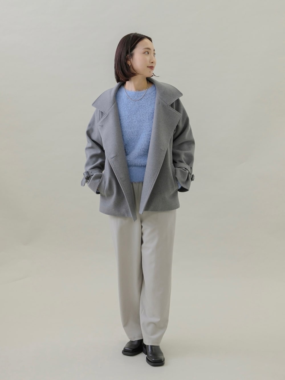 ブラック系のブーツ、グレー系のその他パンツ、ブルー系のニット/セーターを着用したレディースの秋コーディネートの4枚目の写真