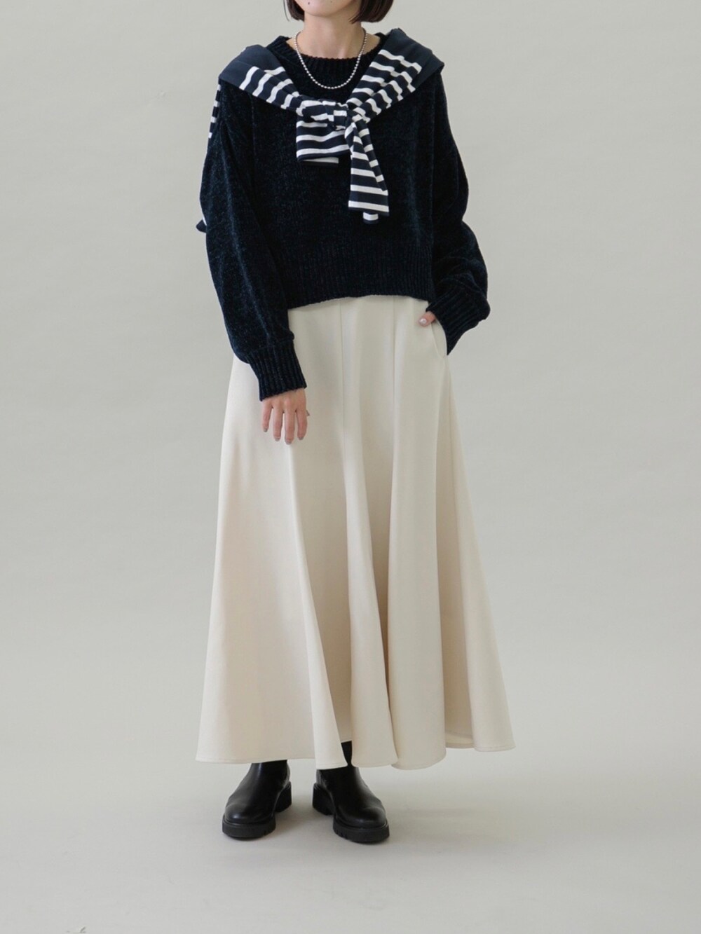 ホワイト系のスカート、ブルー系のTシャツ/カットソー、ブラック系のブーツを着用したレディースの秋コーディネートの4枚目の写真