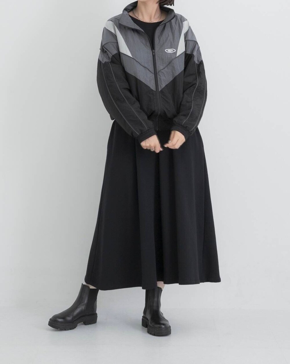 ブラック系のナイロンジャケット、ブラック系のワンピースを着用したレディースの秋コーディネートの3枚目の写真