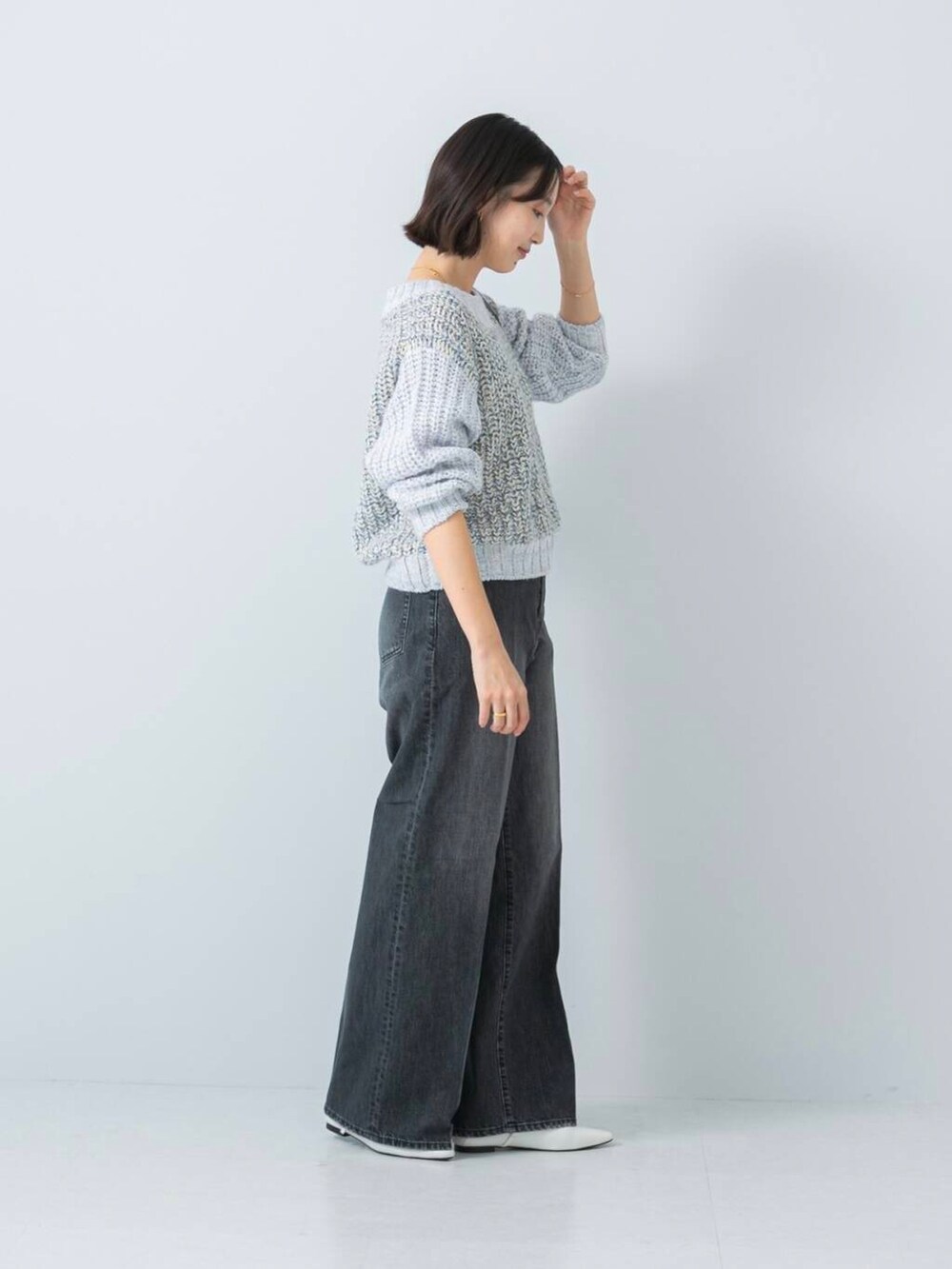 ブルー系のニット/セーター、ブラック系のデニムパンツを着用したレディースの冬コーディネートの2枚目の写真