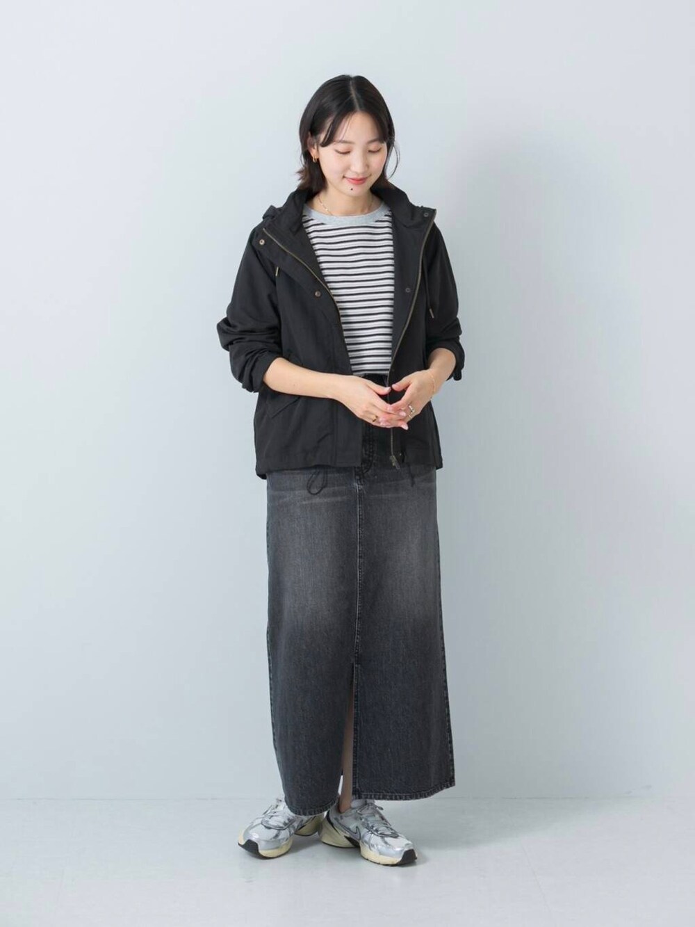 ブラック系のマウンテンパーカー、ブラック系のTシャツ/カットソー、ブラック系のスカートを着用したレディースの冬コーディネートの2枚目の写真
