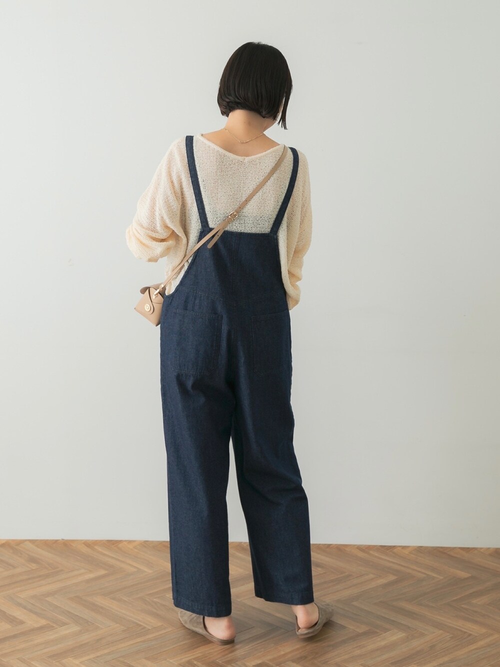 グレー系のスリッポン、ホワイト系のニット/セーター、ブルー系のサロペット/オーバーオールを着用したレディースの夏コーディネートの2枚目の写真