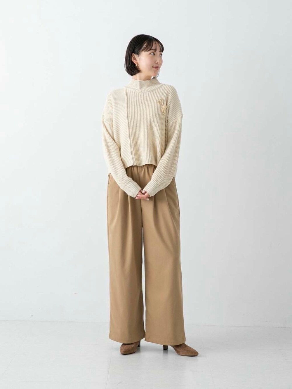 ブラウン系のその他シューズ、ベージュ系のその他パンツ、ホワイト系のニット/セーターを着用したレディースの冬コーディネートの2枚目の写真