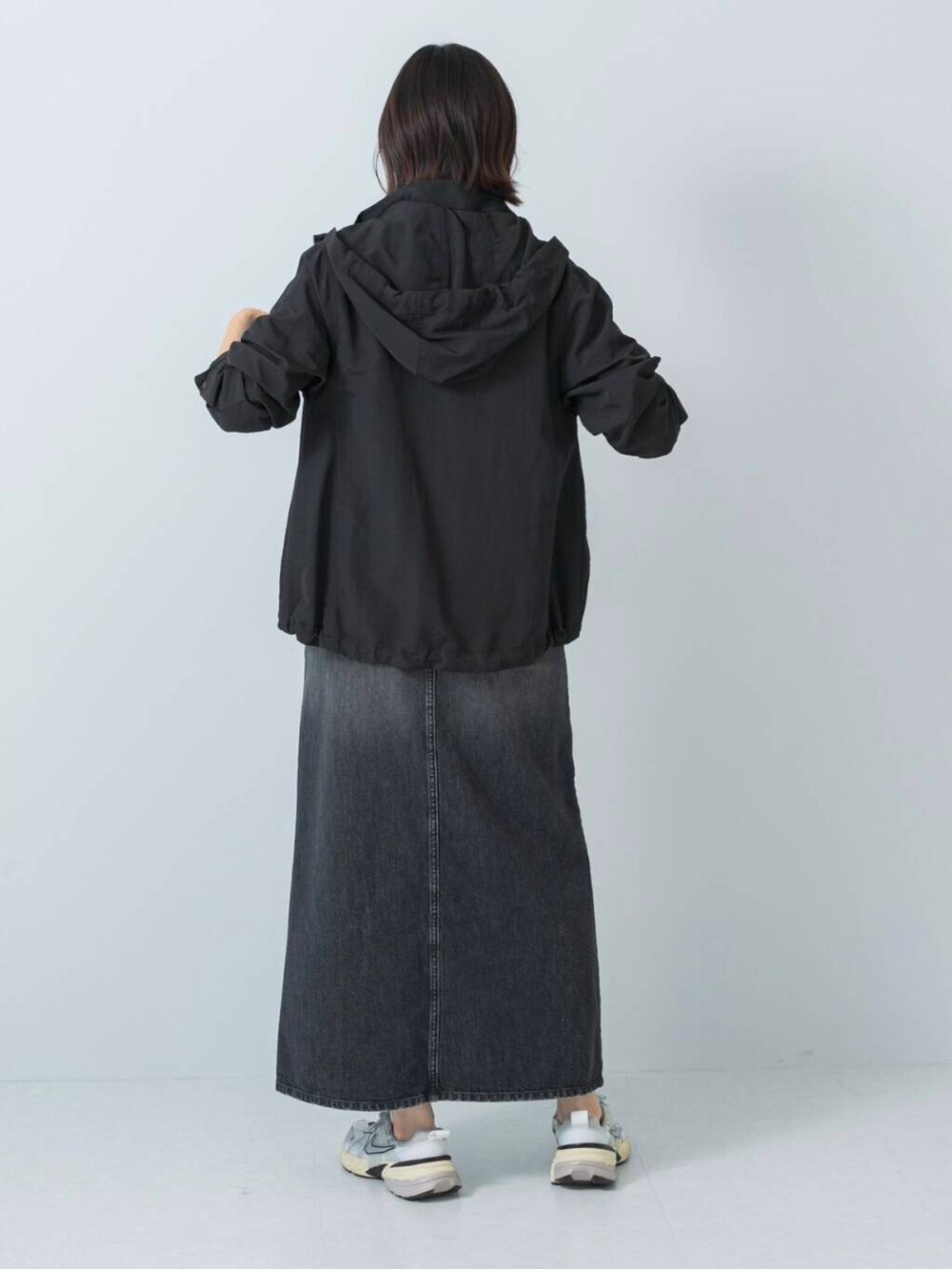 ブラック系のマウンテンパーカー、ブラック系のTシャツ/カットソー、ブラック系のスカートを着用したレディースの冬コーディネートの4枚目の写真