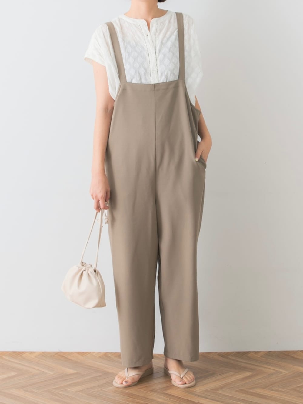 ホワイト系のシャツ/ブラウス、ベージュ系のサロペット/オーバーオール、ベージュ系のサンダルを着用したレディースの夏コーディネートの4枚目の写真