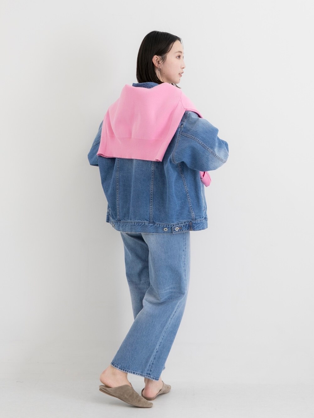 ブルー系のデニムジャケット、ブルー系のデニムパンツ、ピンク系のニット/セーターを着用したレディースの春コーディネートの2枚目の写真