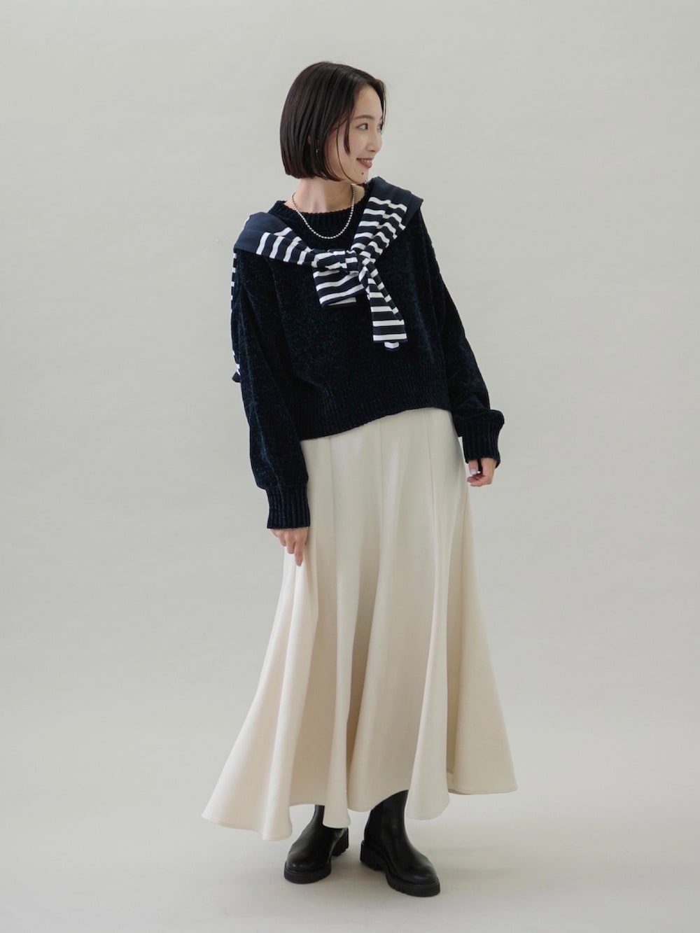 ホワイト系のスカート、ブルー系のTシャツ/カットソー、ブラック系のブーツを着用したレディースの秋コーディネートの2枚目の写真