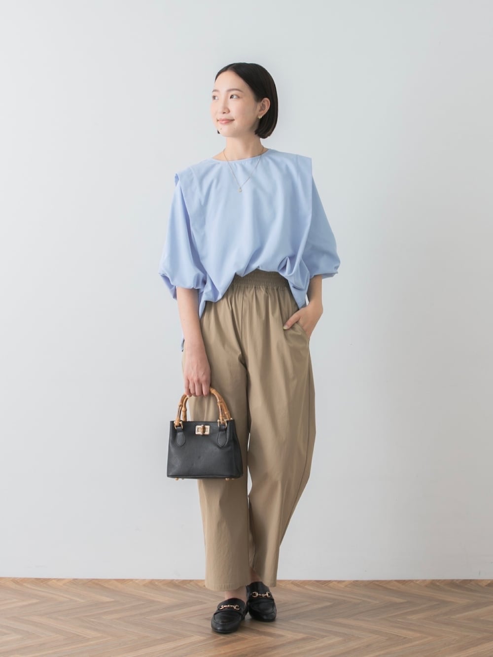 ブルー系のシャツ/ブラウス、ベージュ系のその他パンツ、ブラック系のトートバッグを着用したレディースの秋コーディネートの2枚目の写真