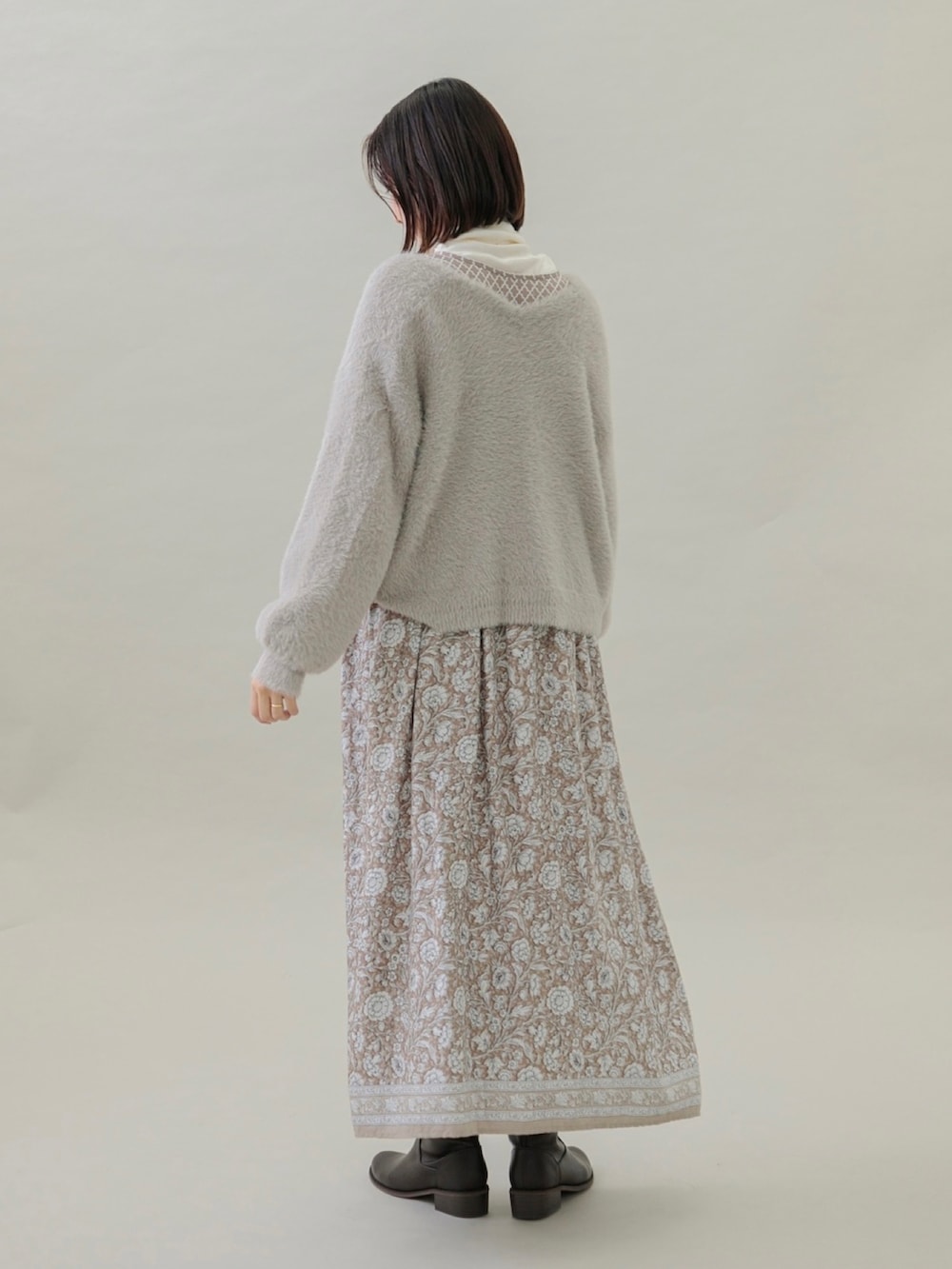 ベージュ系のワンピース、ベージュ系のカーディガン/ボレロ、ブラウン系のブーツを着用したレディースの秋コーディネートの3枚目の写真