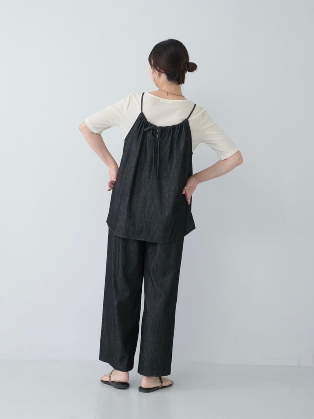 ブラック系のサロペット/オーバーオール、ホワイト系のTシャツ/カットソー、ゴールド系のネックレスを着用したレディースの夏コーディネートの2枚目の写真
