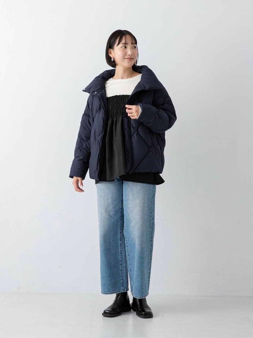 ブルー系のデニムパンツ、ブルー系のダウンジャケット/コート、ホワイト系のTシャツ/カットソーを着用したレディースの冬コーディネートの3枚目の写真