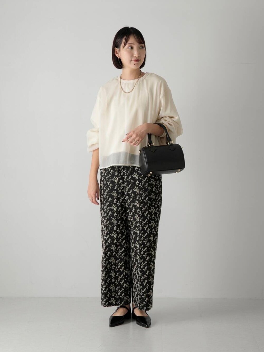 ブラック系のボストンバッグ、ブラック系のその他シューズ、ブラック系のその他パンツを着用したレディースの秋コーディネートの2枚目の写真