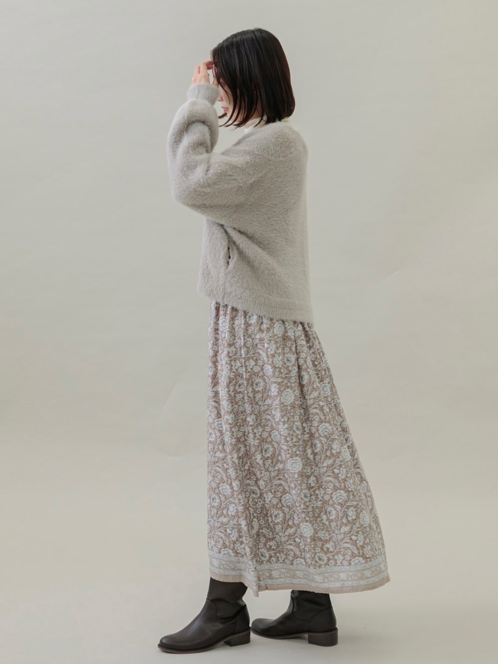 ベージュ系のワンピース、ベージュ系のカーディガン/ボレロ、ブラウン系のブーツを着用したレディースの秋コーディネートの4枚目の写真