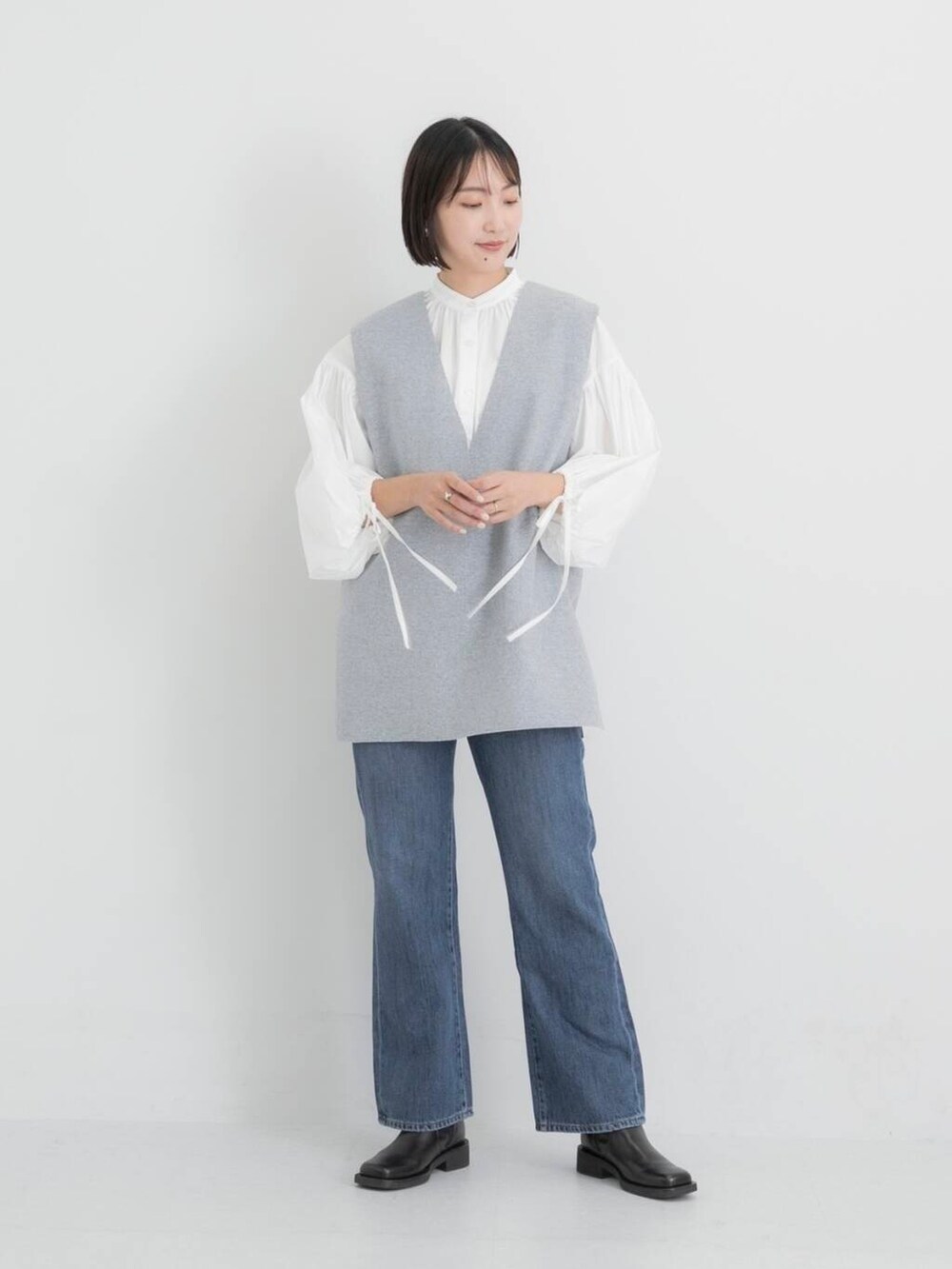 ブルー系のデニムパンツ、ホワイト系のシャツ/ブラウス、グレー系のベストを着用したレディースの秋コーディネートの5枚目の写真