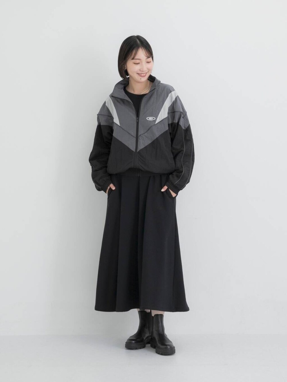 ブラック系のナイロンジャケット、ブラック系のワンピースを着用したレディースの秋コーディネートの2枚目の写真