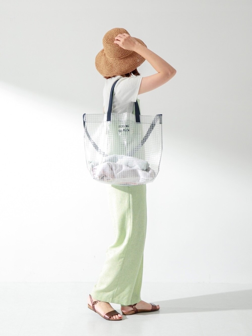 グリーン系のサロペット/オーバーオール、ホワイト系のTシャツ/カットソー、ブラウン系のサンダルを着用したレディースの夏コーディネートの2枚目の写真