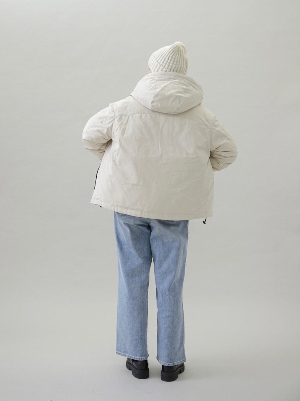 ベージュ系のダウンジャケット/コート、ブルー系のデニムパンツ、ブラック系のブーツを着用したレディースの秋コーディネートの4枚目の写真