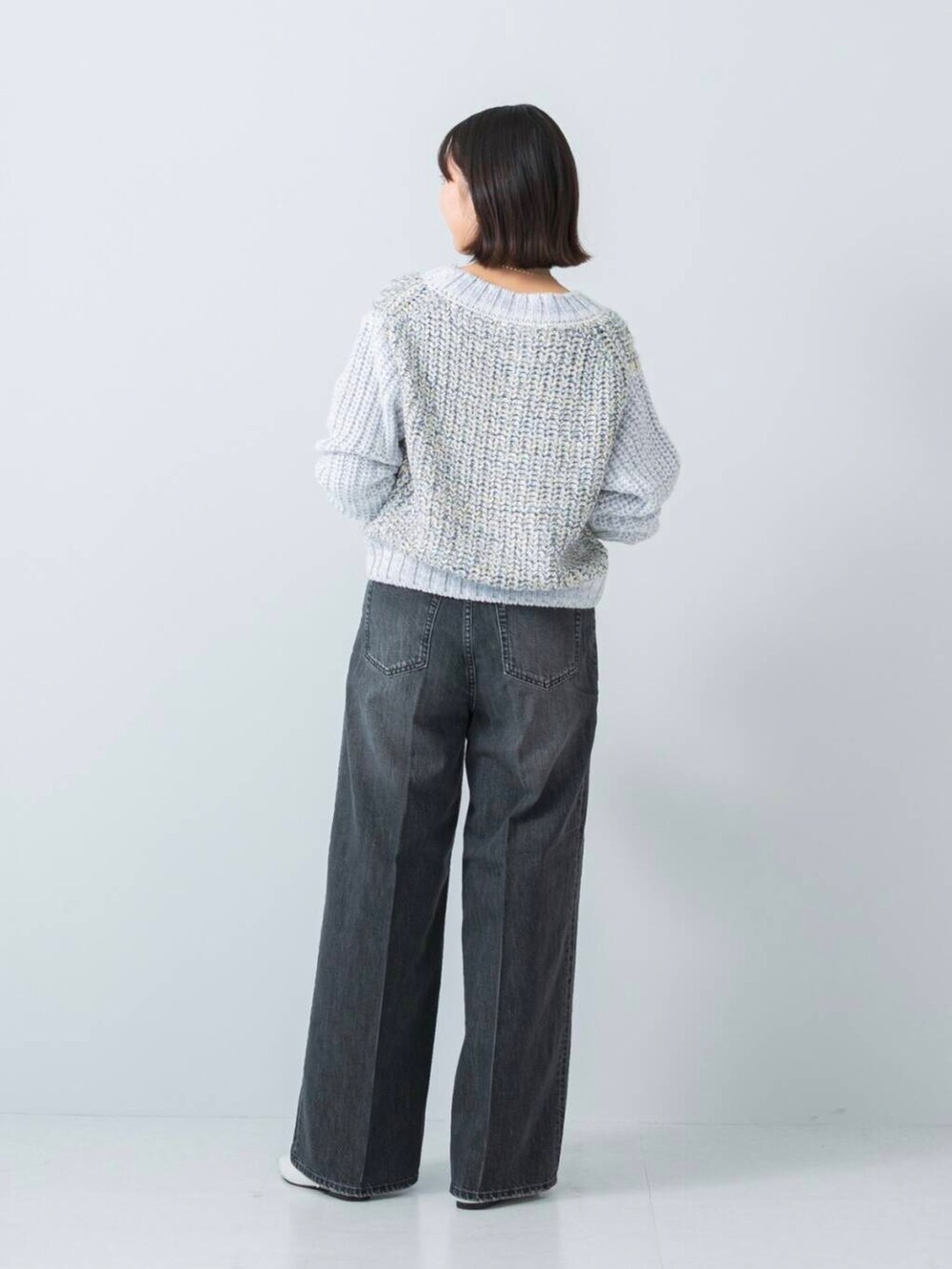 ブルー系のニット/セーター、ブラック系のデニムパンツを着用したレディースの冬コーディネートの3枚目の写真