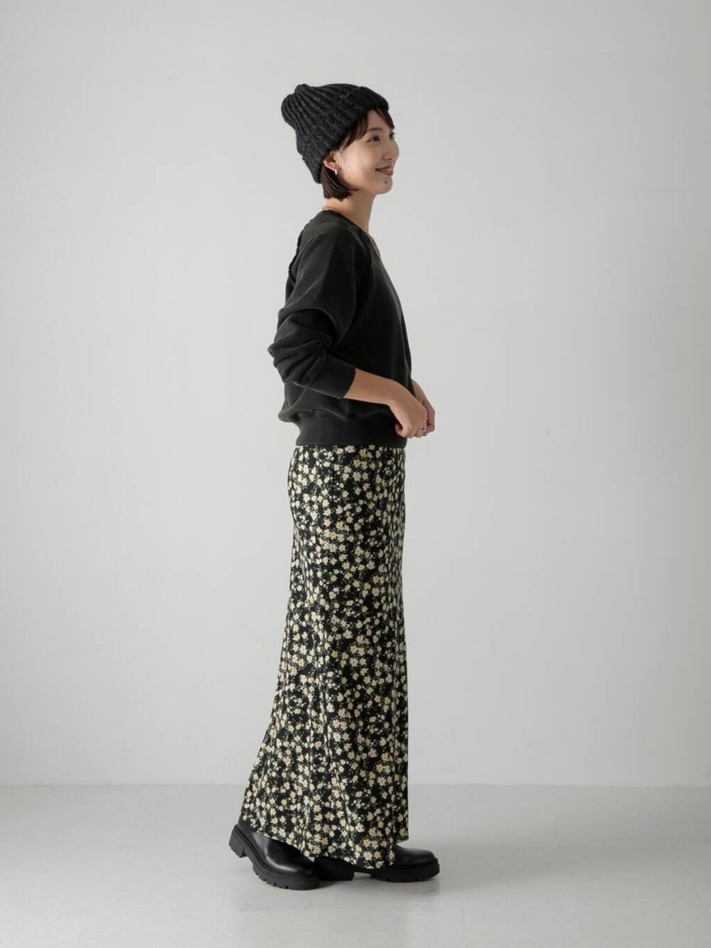 ブラック系のブーツ、ブラック系のスカート、ブラック系のスウェットを着用したレディースの秋コーディネートの2枚目の写真