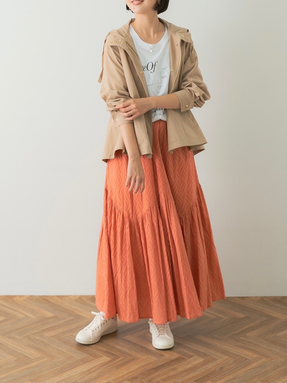 ホワイト系のTシャツ/カットソー、レッド系のスカート、ベージュ系のマウンテンパーカーを着用したレディースの夏コーディネートの4枚目の写真