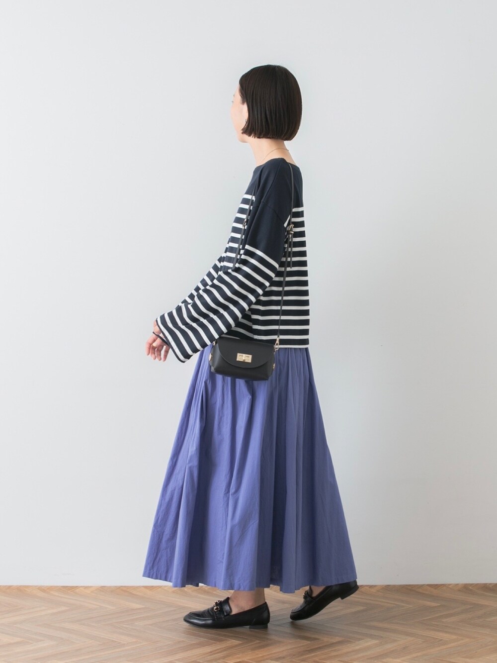 ブルー系のTシャツ/カットソー、ブルー系のスカート、ブラック系のショルダーバッグを着用したレディースの夏コーディネートの2枚目の写真