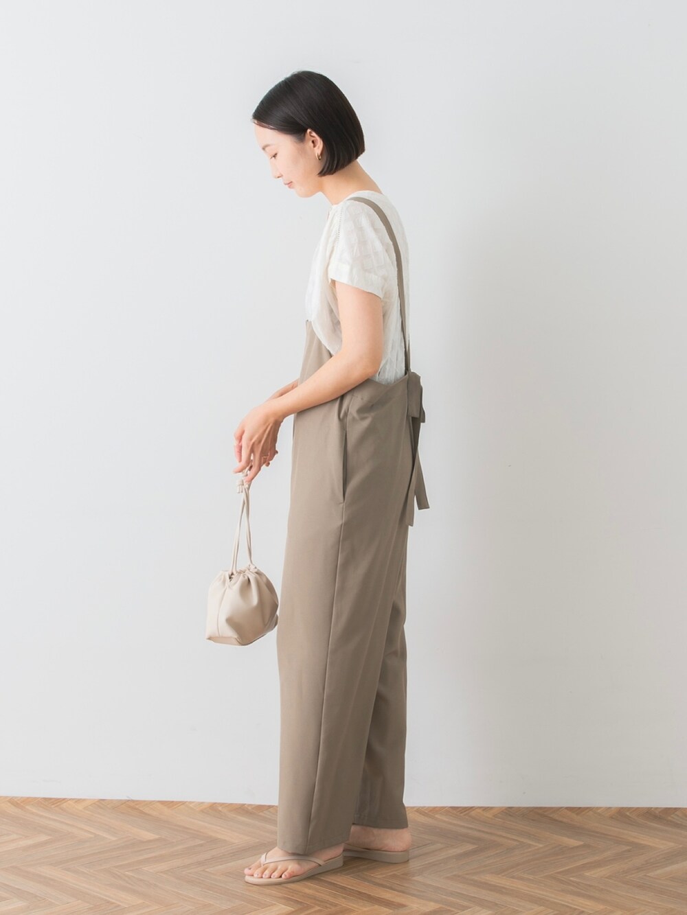 ホワイト系のシャツ/ブラウス、ベージュ系のサロペット/オーバーオール、ベージュ系のサンダルを着用したレディースの夏コーディネートの2枚目の写真