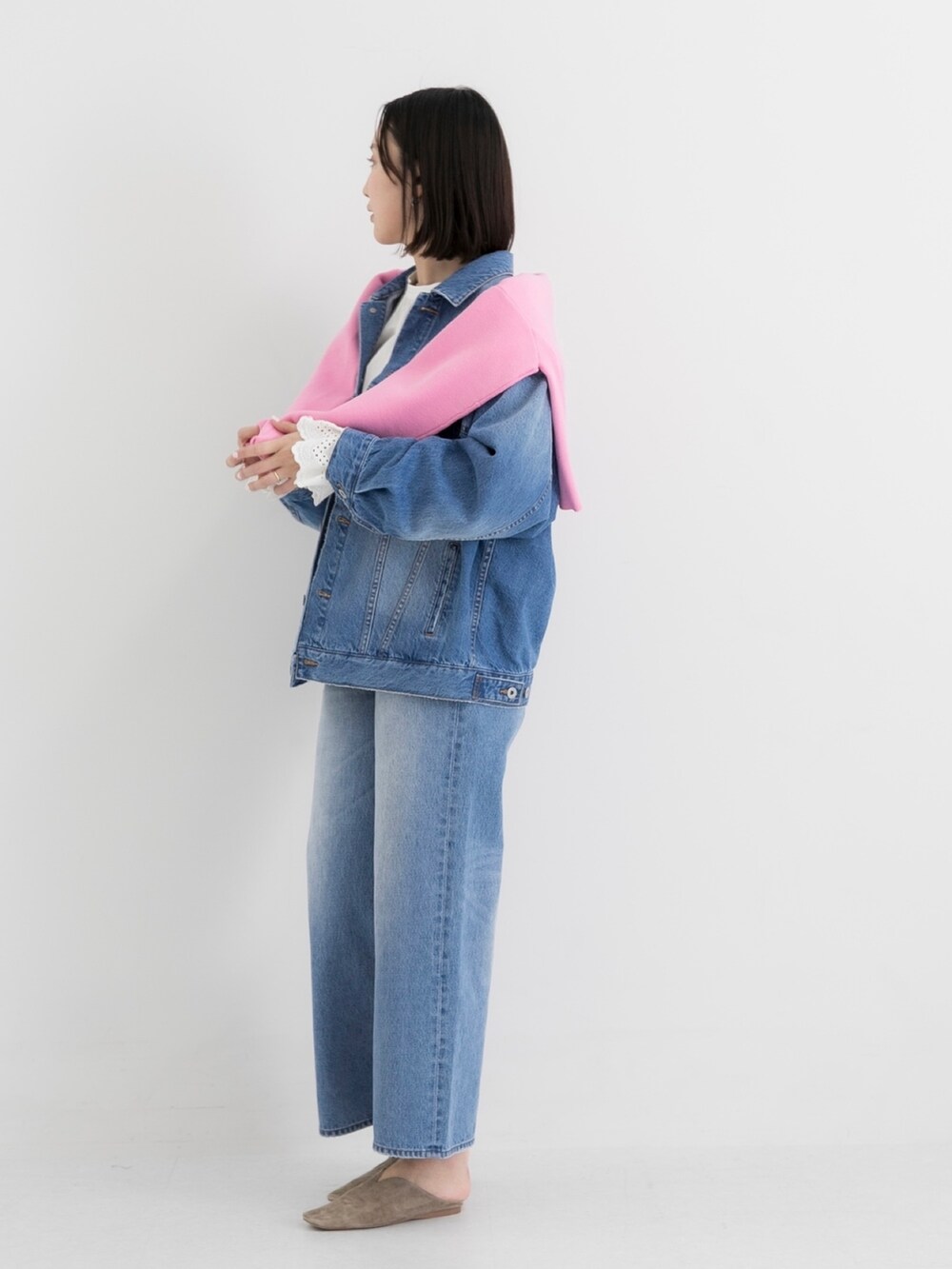 ブルー系のデニムジャケット、ブルー系のデニムパンツ、ピンク系のニット/セーターを着用したレディースの春コーディネートの3枚目の写真