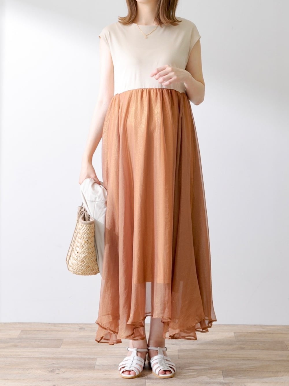 グレー系のTシャツ/カットソー、オレンジ系のワンピース、ホワイト系のサンダルを着用したレディースの夏コーディネートの2枚目の写真