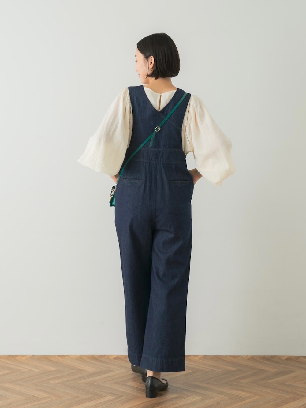 ブルー系のオールインワン・サロペット、グリーン系のショルダーバッグ、ブラック系のバレエシューズを着用したレディースの夏コーディネートの3枚目の写真