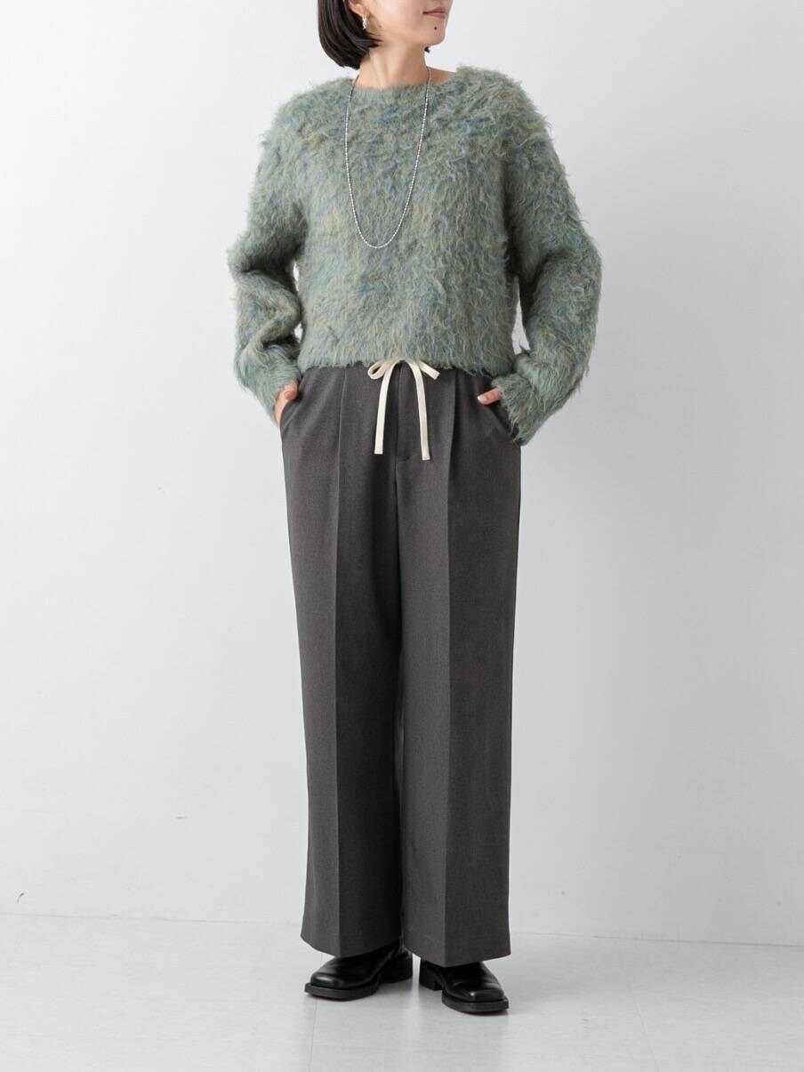 グリーン系のニット/セーター、グレー系のその他パンツを着用したレディースの冬コーディネートの4枚目の写真