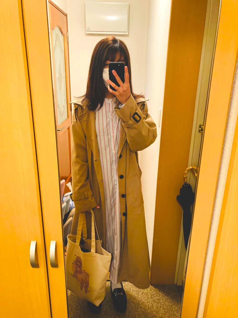 ブルー系のシャツワンピース、ベージュ系のトートバッグを着用したレディースの春コーディネートの3枚目の写真