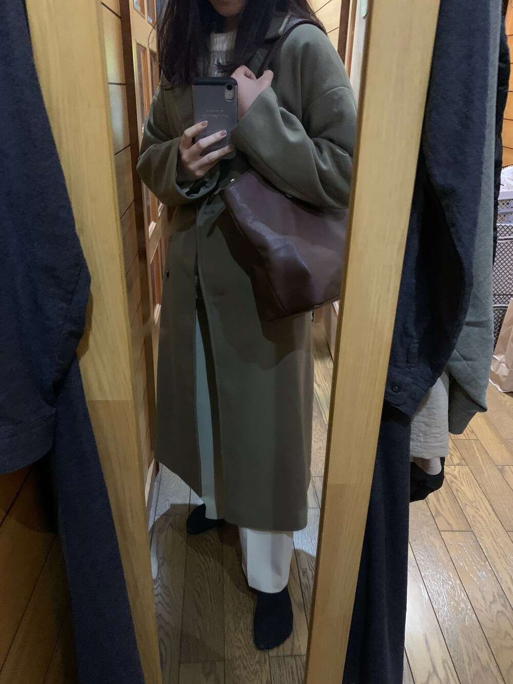 グリーン系のチェスターコート、ベージュ系のショルダーバッグ、ベージュ系のその他パンツを着用したレディースの冬コーディネートの3枚目の写真