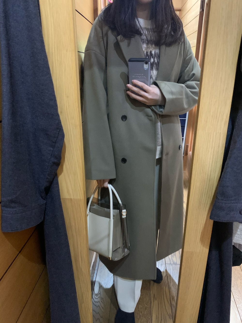 グリーン系のチェスターコート、ベージュ系のショルダーバッグ、ベージュ系のその他パンツを着用したレディースの冬コーディネートの2枚目の写真