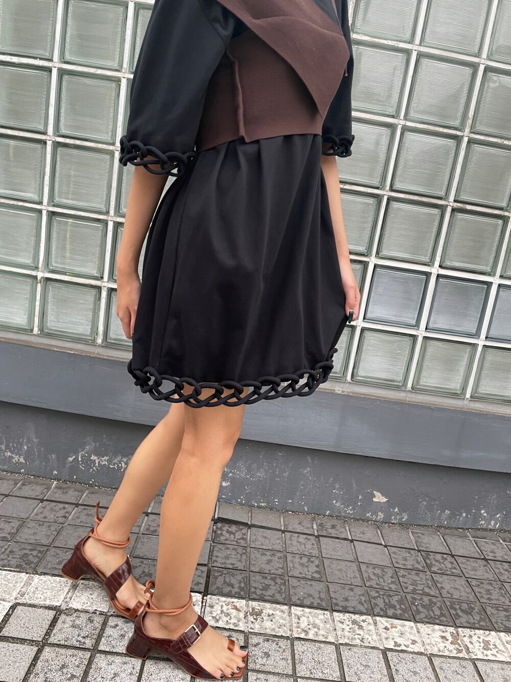ブラウン系のニット/セーター、ブラック系のワンピース、ブラウン系のサンダルを着用したレディースの夏コーディネートの4枚目の写真