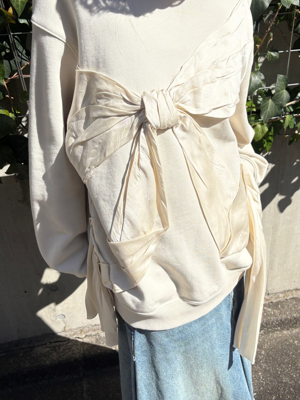 ホワイト系のスウェット、ブルー系のデニムスカートを着用したレディースの冬コーディネートの2枚目の写真