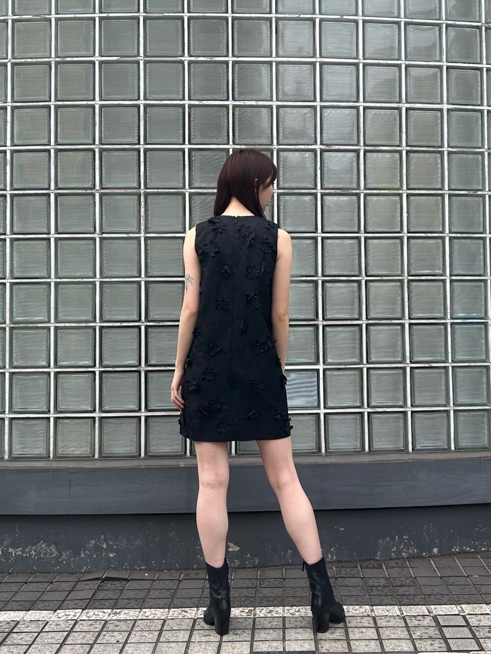 ブラック系のワンピースを着用したレディースの春コーディネートの2枚目の写真