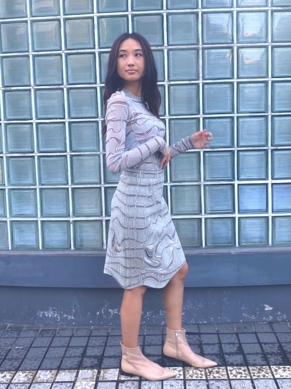 グレー系のTシャツ/カットソー、グレー系のスカート、ブラック系のブーティを着用したレディースの夏コーディネートの4枚目の写真