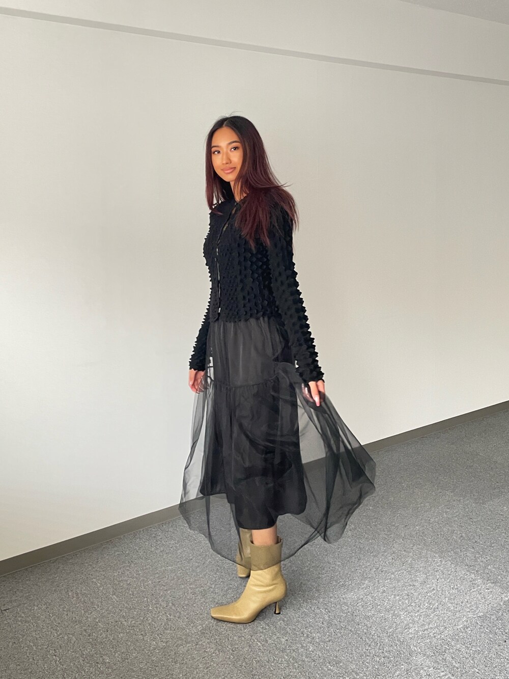 ブラック系のスカート、ブラック系のニット/セーター、ベージュ系のシューズを着用したレディースの秋コーディネートの2枚目の写真