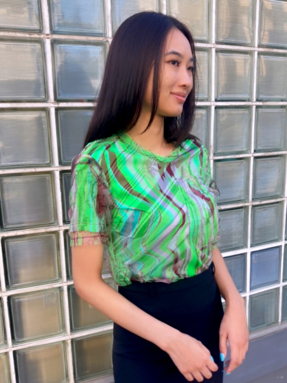 グリーン系のTシャツ/カットソー、ブラック系のスカートを着用したレディースの夏コーディネートの2枚目の写真