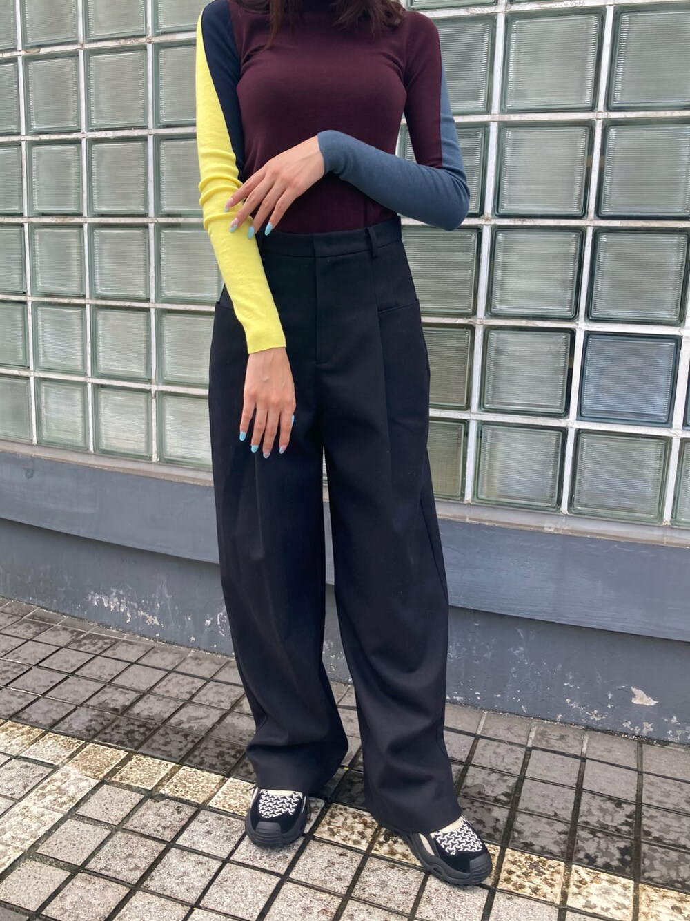 ブラウン系のニット/セーター、ブラック系のその他パンツ、ブラック系のスニーカーを着用したレディースの秋コーディネートの3枚目の写真