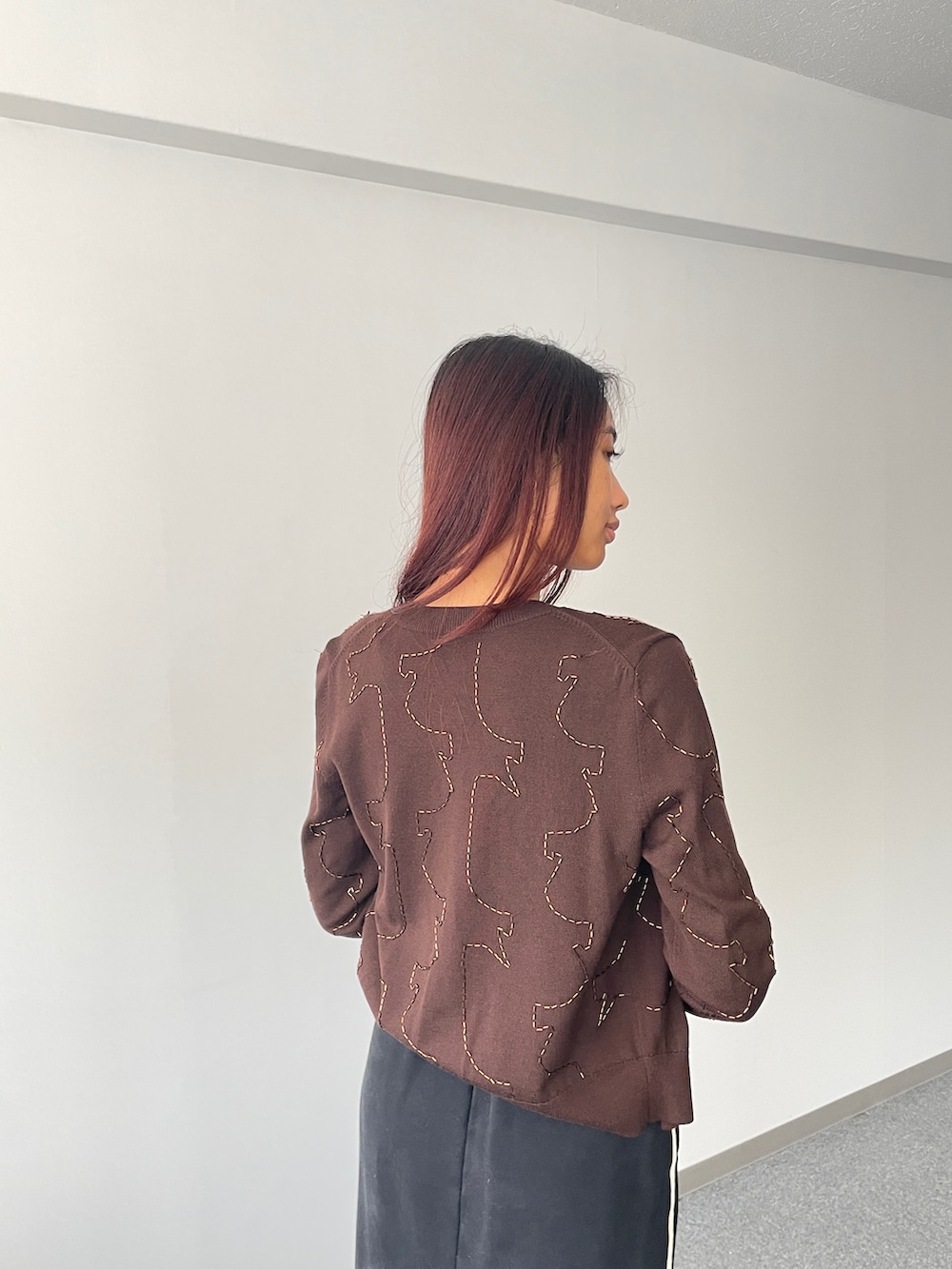 ブラウン系のカーディガン/ボレロ、ベージュ系のタンクトップ、ブラック系のスカートを着用したレディースの秋コーディネートの3枚目の写真