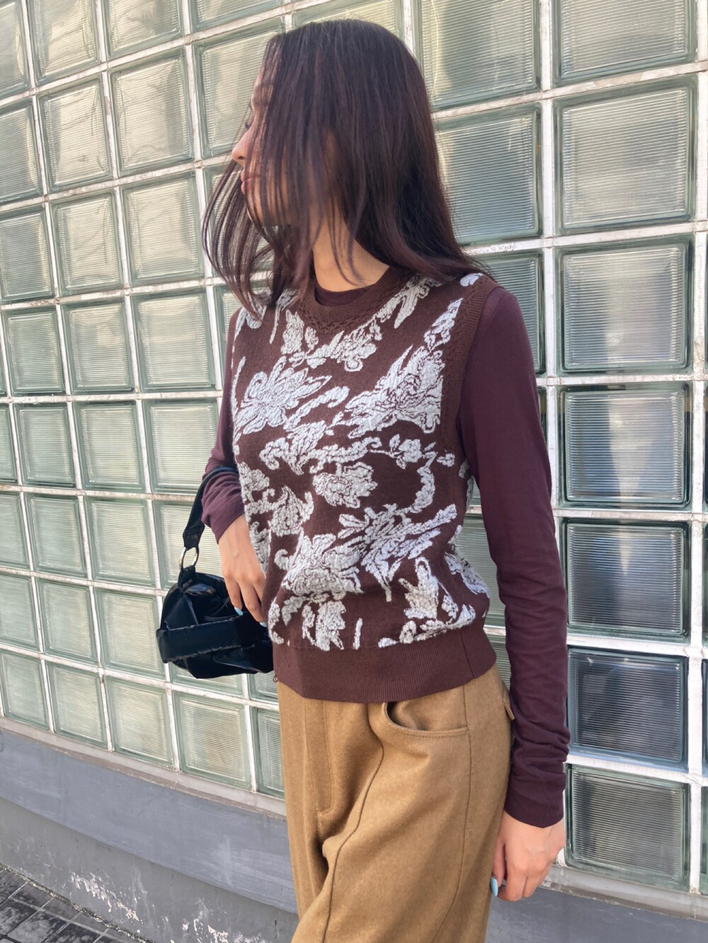 ブラウン系のベスト、ブラック系のその他パンツ、ブラック系のバッグを着用したレディースの秋コーディネートの4枚目の写真