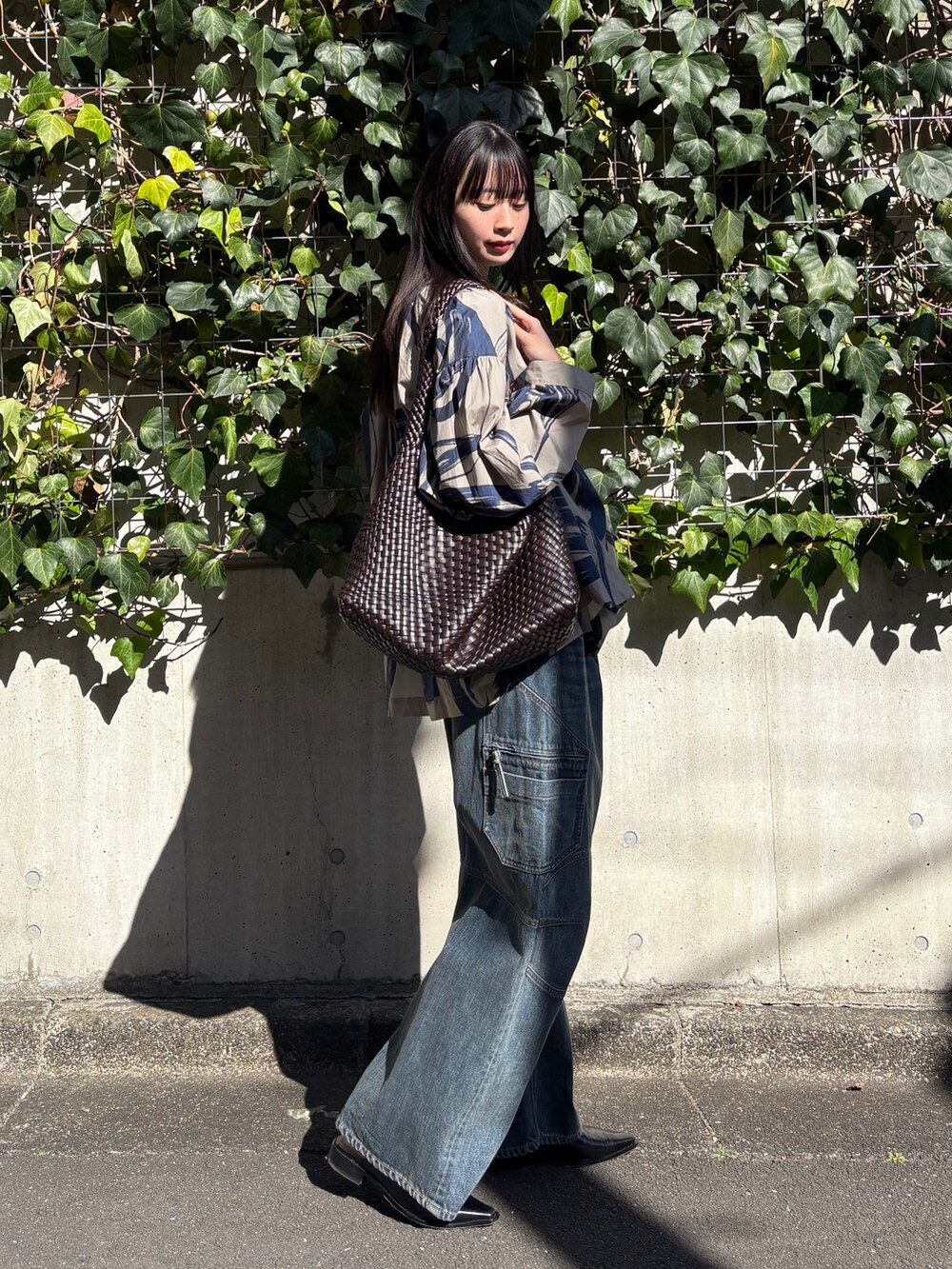 ベージュ系のシャツ/ブラウス、ブルー系のデニムパンツ、ブラウン系のバッグを着用したレディースの冬コーディネートの2枚目の写真